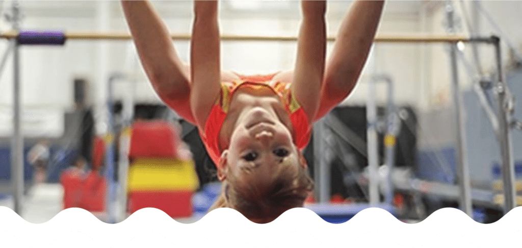 Young Gymnastics Student Hanging Upside Down